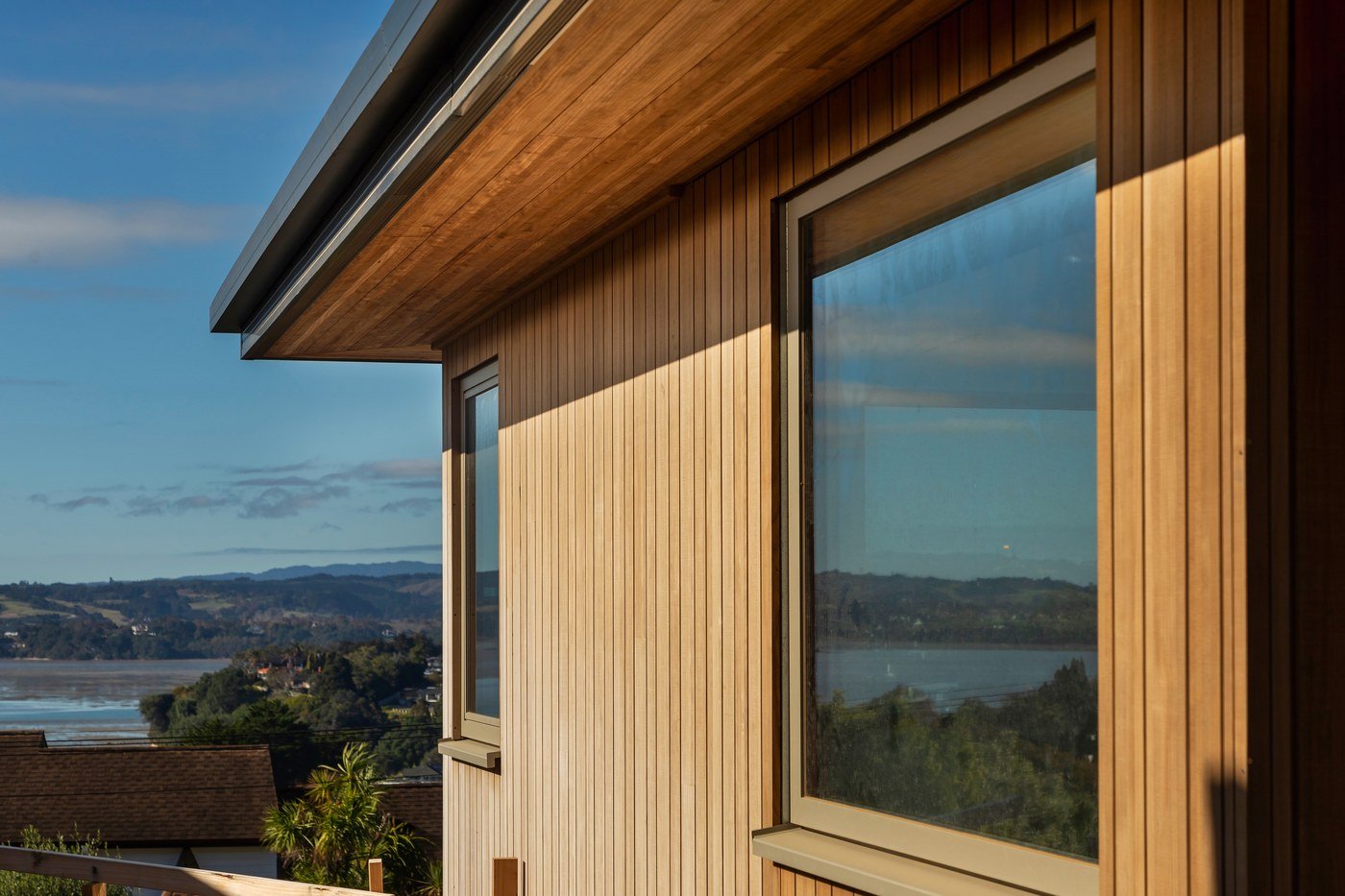 Modern timber-clad home with lake view showcasing WinDor's European window systems